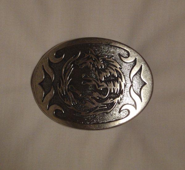 a silver belt buckle with a wolf logo